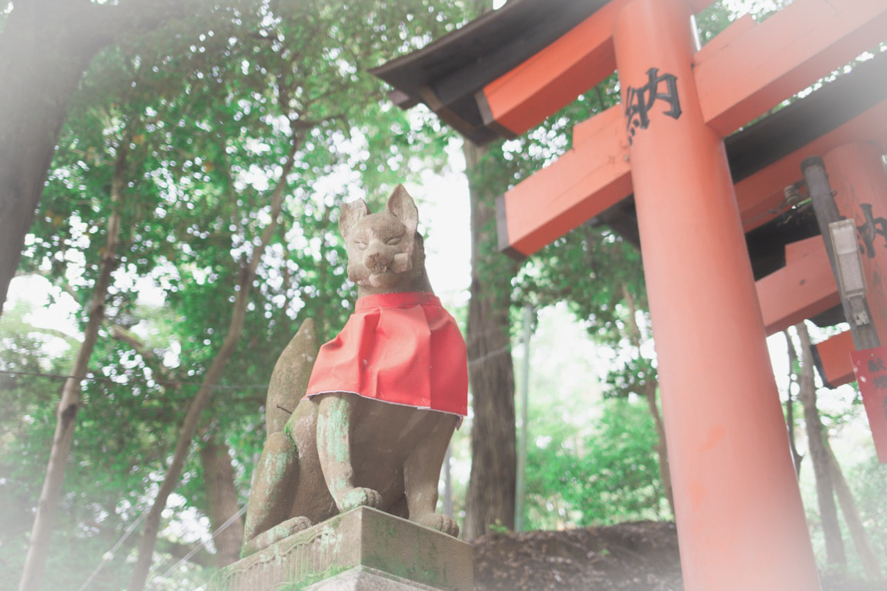 伏見稲荷大社の狐の石像と赤鳥居。